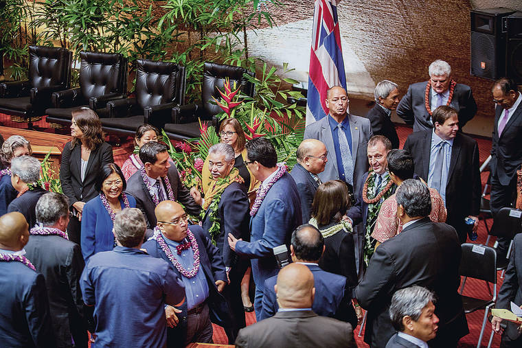 DENNIS ODA / JAN. 22
                                Gov. David Ige, center, was surrounded by legislators and attendees in January after giving his State of the State address in the House Chamber at the state Capitol.
