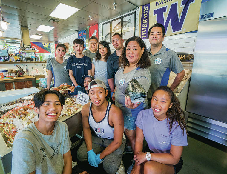 DENNIS ODA / DODA@STARADVERTISER.COM
                                Employees from Seattle Fish Guys pose for a photo on Aug. 4.
