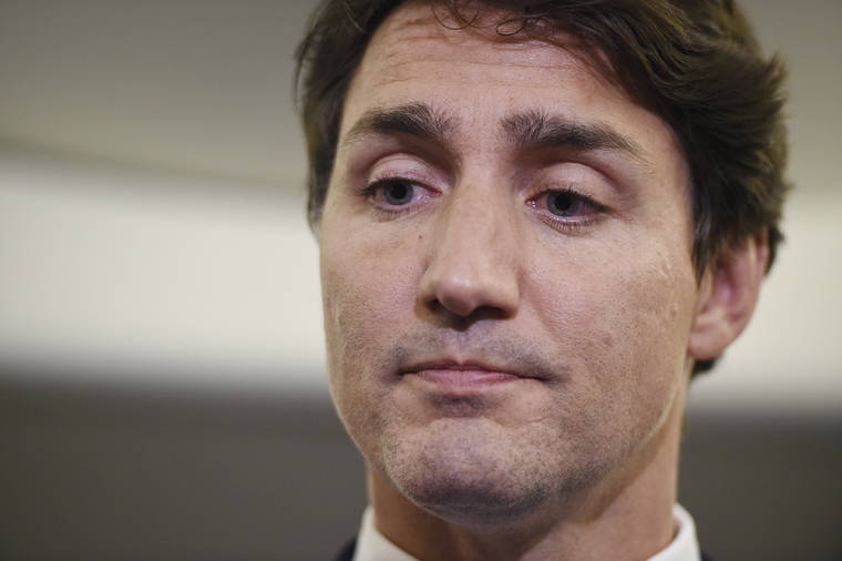 SEAN KILPATRICK/THE CANADIAN PRESS VIA AP
                                Canadian Prime Minister and Liberal Party leader Justin Trudeau reacts as he makes a statement in regards to a photo coming to light of himself from 2001, wearing “brownface,” during a scrum on his campaign plane in Halifax, Nova Scotia.