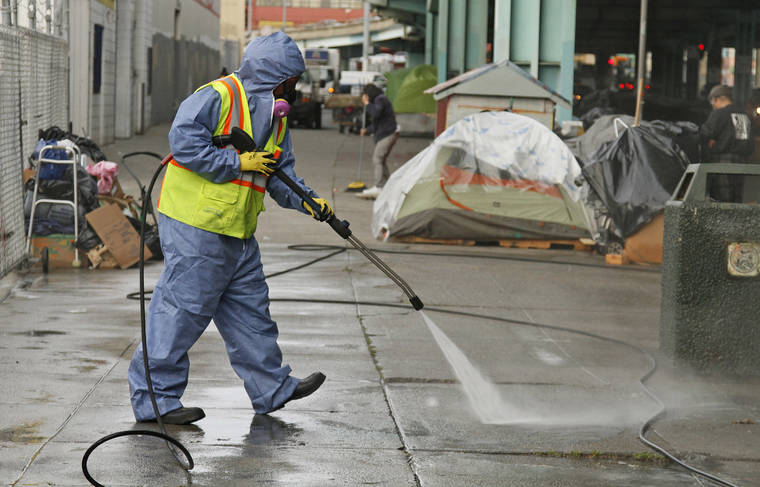 ASSOCIATED PRESS
                                A city worker uses a power washer to clean the sidewalk by a tent city along Division Street in San Francisco in 2016. The U.S. Environmental Protection Agency says California is falling short on preventing water pollution, largely because of its problem with homelessness in cities such as Los Angeles and San Francisco.