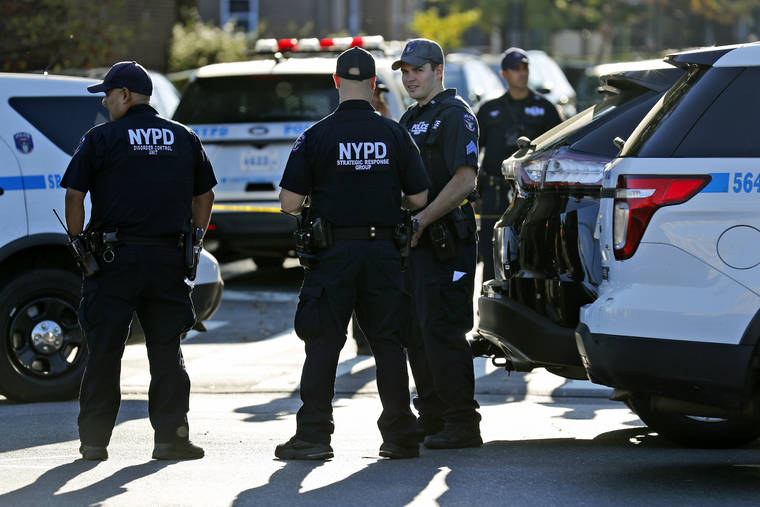 ASSOCIATED PRESS
                                Emergency personnel stand near the scene of a fatal shooting of a police officer in the Bronx borough of New York today.