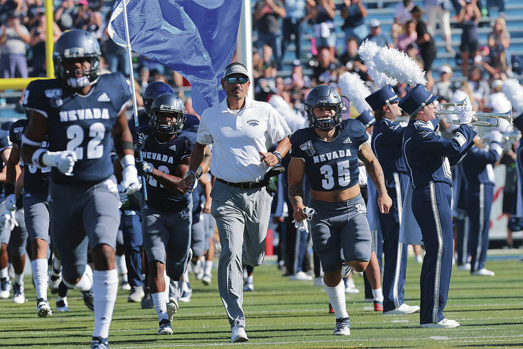 ASSOCIATED PRESS
                                Nevada coach Jay Norvell, center, led the Wolf Pack onto the field to face Weber State in Reno, Nev., on Sept. 14. Norvell is 14-15 in his career at Nevada.