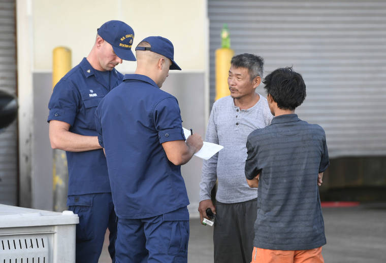 BRUCE ASATO / BASATO@STARADVERTISER.COM
                                The U.S. Coast Guard gathers information from the crew of a commercial fishing vessel that caught fire off of Sand Island this afternoon.