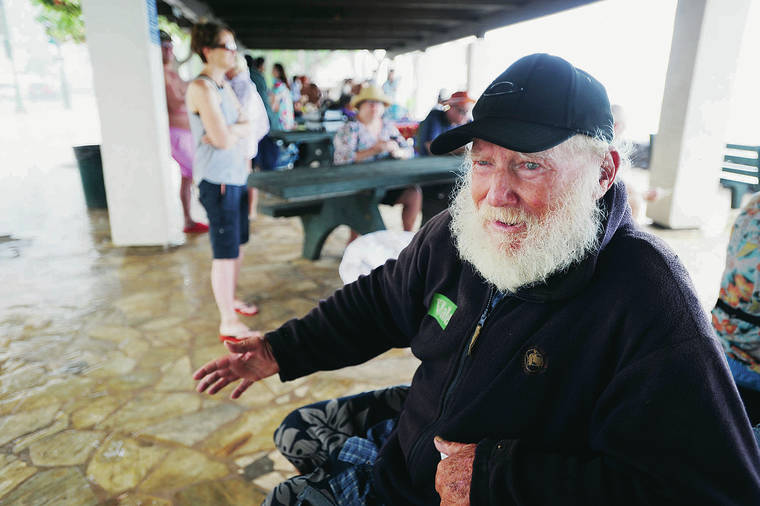 BRUCE ASATO / BASATO@STARADVERTISER.COM
                                Vietnam War veteran James Brewer, above, sought shelter from the rain under a covered area facing Waikiki Beach. Brewer is known as “Skipper” because of his resemblance to the “Gilligan’s Island” TV character.