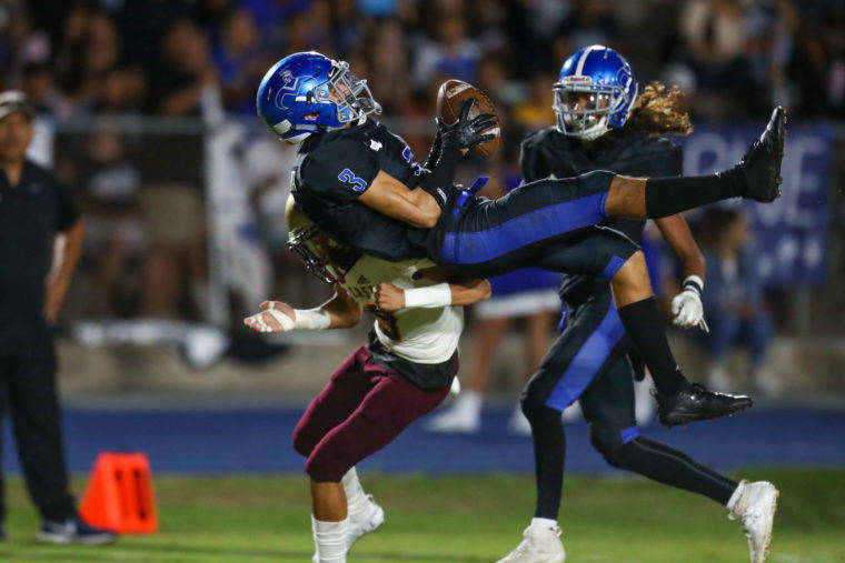 DARRYL OUMI / SPECIAL TO THE HONOLULU STAR-ADVERTISER
                                Moanalua’s Christian Sison (3) falls backward as he intercepts a pass during the game against the Castle Knights at the Moanalua High School field.