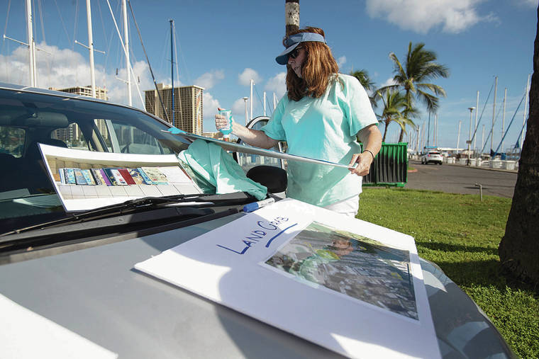 CINDY ELLEN RUSSELL / CRUSSELL@STARADVERTISER.COM
                                Longtime boat owner Kate Thompson makes signs for the protest.
