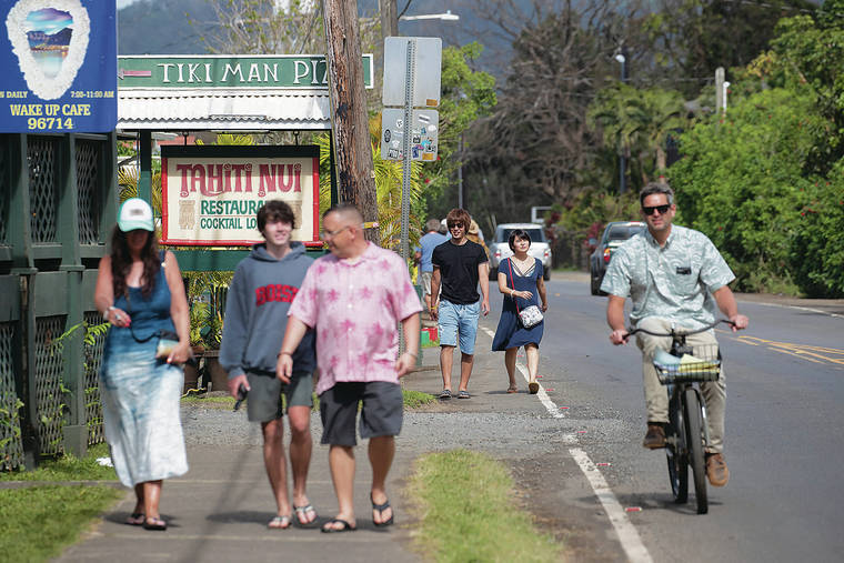 CINDY ELLEN RUSSELL / MARCH 22
                                The Aloha Pledge program was introduced on Kauai after the devastating north shore flooding. Visitors walk along Kuhio Highway in Hanalei, Kauai.