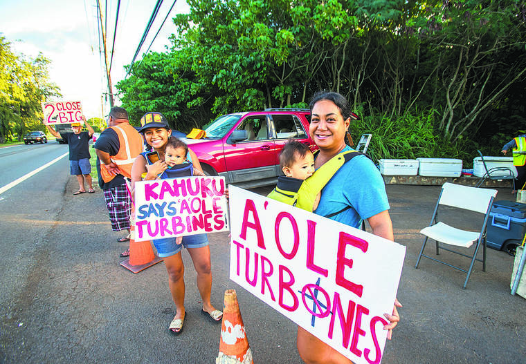 DENNIS ODA / DODA@STARADVERTISER.COM
                                Kuhi Southard and Jamie Rezentes-Ah Quin were among protesters attempting to stop the construction of wind turbines in Kahuku on Tuesday.