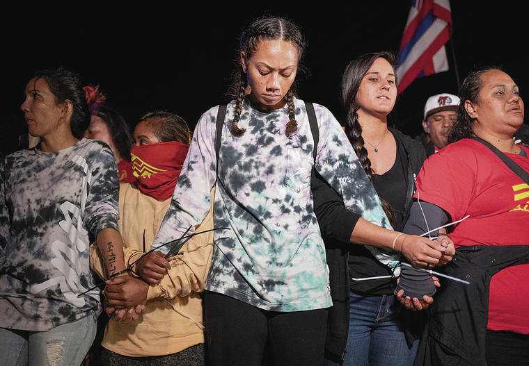 CINDY ELLEN RUSSELL / CRUSSELL@STARADVERTISER.COM
                                Bound together in solidarity before their arrest late Sunday night at Kalaeloa were Jesse Cabael, left, Amanda Aquino, Kiana Lei, Alison Hartmann and Davina Sanders.