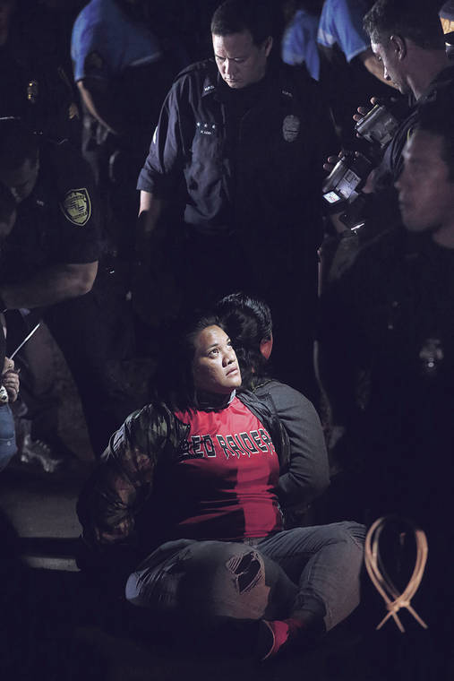 KAT WADE / SPECIAL TO THE STAR-ADVERTISER
                                Protesters sat on a roadway Monday night in Kalaeloa, trying to block the convoy of turbine parts from getting started on the journey to Kahuku.