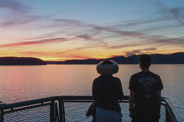 NEW YORK TIMES
                                Tourists watch the sunset from a ferry between Anacortes and Orcas, Wash. Orcas has all the ingredients of a perfect solo trip and outdoorsy fun abounds, with mountain biking, kayaking and whale watching — all ideal ways to eat up a summer day.