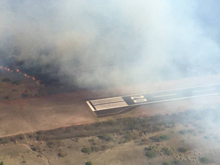 COURTESY HAWAII DEPT. OF TRANSPORTATION
                                The brush fire, Tuesday, reached the Kapalua Airport’s runway, according to Maui County officials.