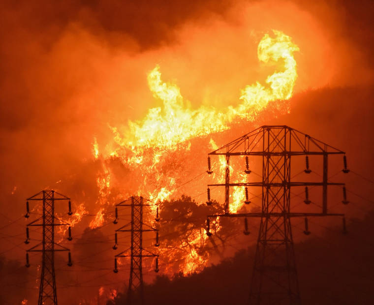 ASSOCIATED PRESS
                                In this Dec. 16, 2017, photo provided by the Santa Barbara County Fire Department, flames burn near power lines in Sycamore Canyon near West Mountain Drive in Montecito, Calif.