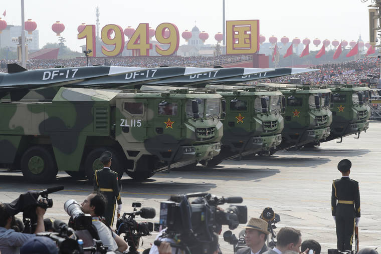 ASSOCIATED PRESS
                                Military vehicles, carrying DF-17, roll down as members of a Chinese military honor guard march during the parade to commemorate the 70th anniversary of the founding of Communist China in Beijing, today.