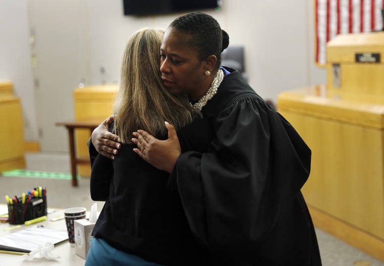 ASSOCIATED PRESS
                                State District Judge Tammy Kemp gives former Dallas Police Officer Amber Guyger a hug before Guyger leaves for jail, Wednesday, in Dallas. Guyger, who said she mistook neighbor Botham Jean’s apartment for her own and fatally shot him in his living room, was sentenced to a decade in prison.