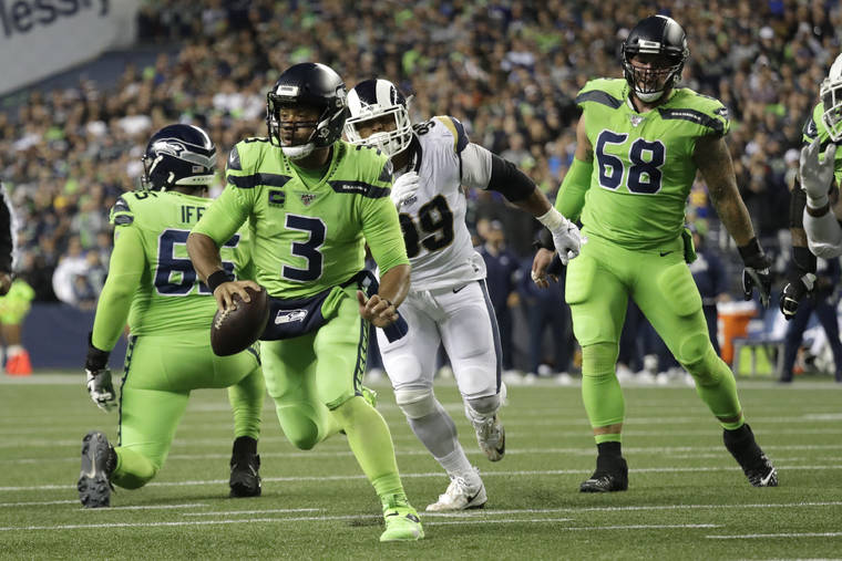ASSOCIATED PRESS
                                Seattle Seahawks quarterback Russell Wilson (3) scrambles before making a short pass to running back Chris Carson for a touchdown against the Los Angeles Rams during the second half of an NFL football game today in Seattle.