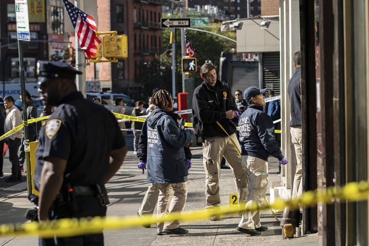 ASSOCIATED PRESS
                                New York Police Department officers investigate the scene of an attack in Manhattan’s Chinatown neighborhood in New York. Four men who are believed to be homeless were attacked and killed early Saturday in a street rampage. NYPD Detective Annette Shelton said that a fifth man remained in critical condition after also being struck with a long metal object that authorities recovered.