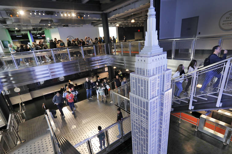 ASSOCIATED PRESS
                                Visitors to the Empire State Building pass a scale model of the building as they begin their visit, in New York. The world-famous observatory atop the Empire State Building has a dizzying new look with floor-to-ceiling, 360-degree windows 102 floors above New York City.
