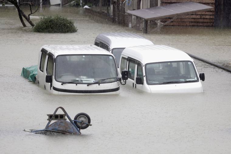 KYODO NEWS VIA AP
                                Cars sit submerged in water in the residential area hit by Typhoon Hagibis, in Ise, central Japan. A heavy downpour and strong winds pounded Tokyo and surrounding areas on Saturday as a powerful typhoon forecast as the worst in six decades approached landfall, with streets and train stations deserted and shops shuttered.