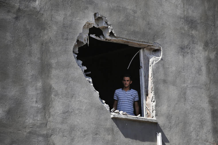 ASSOCIATED PRESS
                                A local resident looks out from a hole on a house that was damaged by a mortar fire from inside Syria, on the Turkish town of Akcakale, southeaster, Turkey. Nobody got hurt by the attack. The owners of the house weren’t home at the time of the attack. Turkey’s military said it captured a key Syrian border town under heavy bombardment Saturday as its offensive against Kurdish fighters pressed into its fourth day with little sign of relenting despite mounting international criticism.