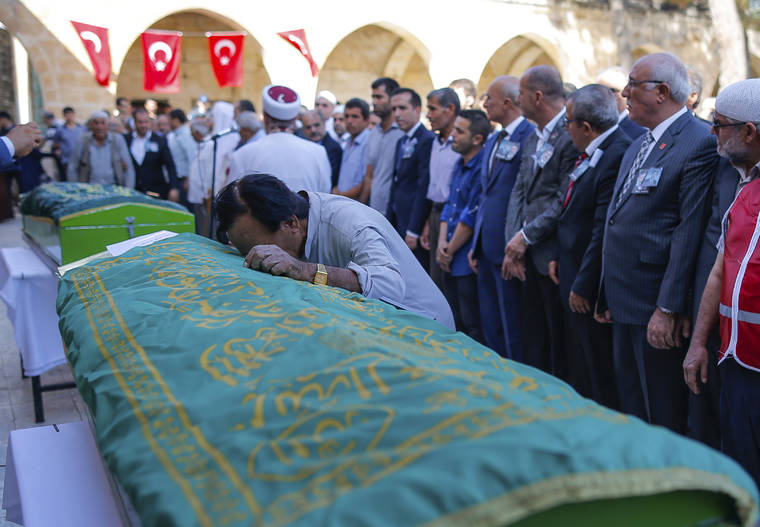 ASSOCIATED PRESS
                                A mourner cries on the coffin of Halil Yagmur, 64, killed Friday during mortar shelling from Syria, during a funeral procession in the town of Suruc, southeastern Turkey, at the border with Syria.