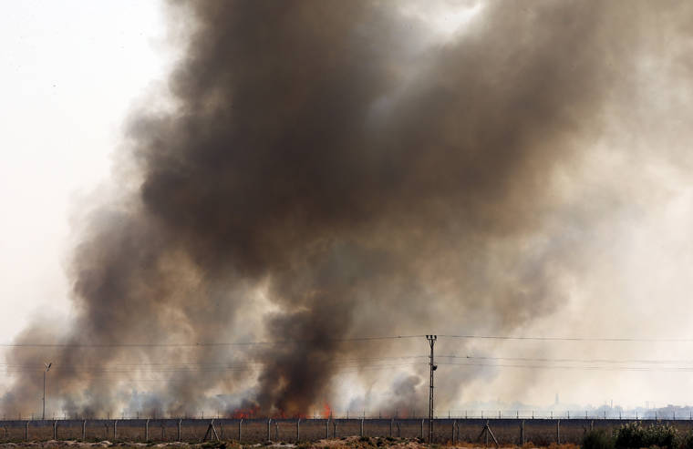ASSOCIATED PRESS
                                In this photo taken from the Turkish side of the border between Turkey and Syria, smoke billows from fires on targets in Tel Abyad, Syria.