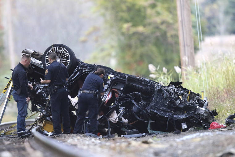 ASSOCIATED PRESS
                                Emergency personnel survey the remains of a Porsche SUV that plummeted off an overpass onto train tracks below Sunday afternoon, where it burst into flames, killing two teenagers and sending a third to a hospital with serious injuries in Pearl River, NY, on Sunday.