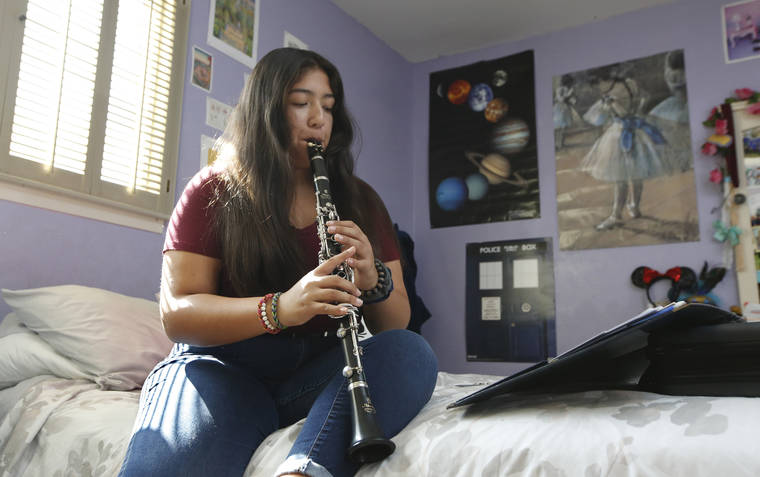 ASSOCIATED PRESS
                                Briana Lopez, a freshman at Lincoln High School and a member of the school’s band, practices the clarinet at her home in Lincoln, Calif. today. California has become the first state to enact a start time for public high schools and middle schools. Gov. Gavin Newsom signed a law Sunday that bans most high schools from starting before 8:30 a.m. and most middle schools from starting before 8 a.m.