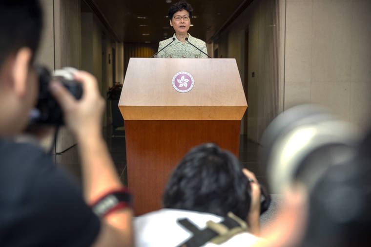 ASSOCIATED PRESS
                                Journalists take photos as Hong Kong Chief Executive Carrie Lam speaks during a press conference at the government building in Hong Kong, Tuesday.