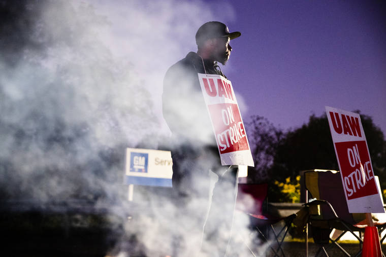 ASSOCIATED PRESS
                                Omar Glover pickets outside a General Motors facility in Langhorne, Pa., on Sept. 27. A tentative four year contract with striking General Motors gives workers a mix of pay raises, lump sum payments and an $11,000 signing bonus.
