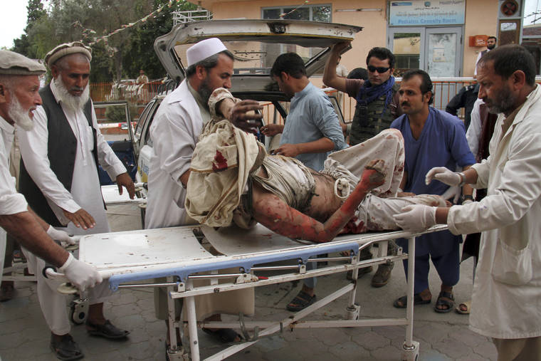 ASSOCIATED PRESS
                                A wounded man is brought by stretcher into a hospital after a mortar was fired by insurgents in Haskamena district of Jalalabad east of Kabul, Afghanistan, today. An Afghan official says scores of people have been killed during Friday prayers when a mortar fired by insurgents blasted through the roof of a mosque.