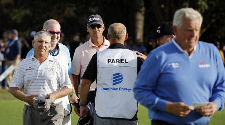 ASSOCIATED PRESS
                                Co-leaders Scott Parel, left, and Tommy Toles, wearing cap, walk off the final hole at 12 under par, one stroke ahead of Colin Montgomerie, right, after the second round of the Dominion Energy Charity Classic golf tournament in Richmond, Va., on Saturday. Montgomerie missed a tying birdie attempt after engaging noisy fans in the stands.