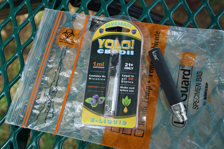 ASSOCIATED PRESS
                                A Yolo! brand CBD oil vape cartridge sat alongside a vape pen, May 8, on a biohazard bag on a table at a park in Ninety Six, S.C. More than 50 people around Salt Lake City had been poisoned by the time the outbreak ended early last year, most by a vape called Yolo!, the acronym for “you only live once.”