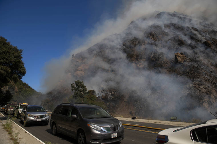 ASSOCIATED PRESS
                                Palisades residents flee the area as a wildfire erupts in the Pacific Palisades area of Los Angeles on Monday.