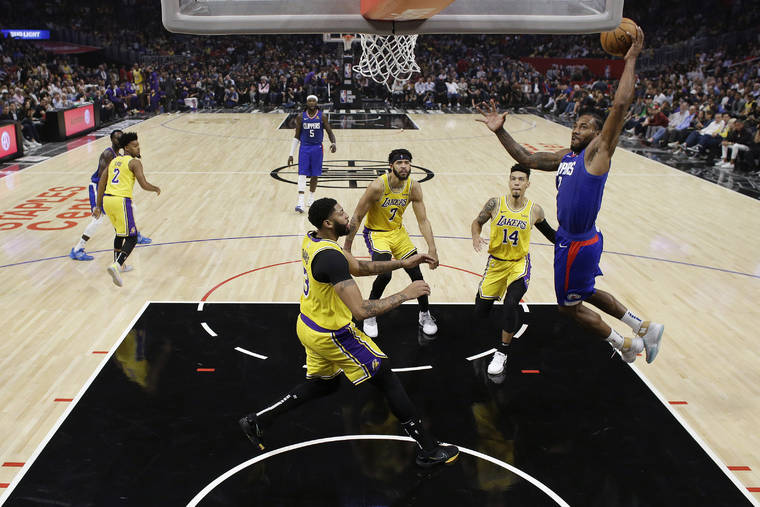 ASSOCIATED PRESS
                                Los Angeles Clippers’ Kawhi Leonard, right, dunks against the Los Angeles Lakers during the first half of an NBA basketball game today in Los Angeles.