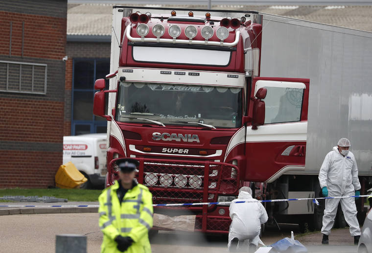 ASSOCIATED PRESS
                                Police forensic officers attended the scene after a truck was found to contain a large number of dead bodies, in Thurrock, South England, Wednesday.