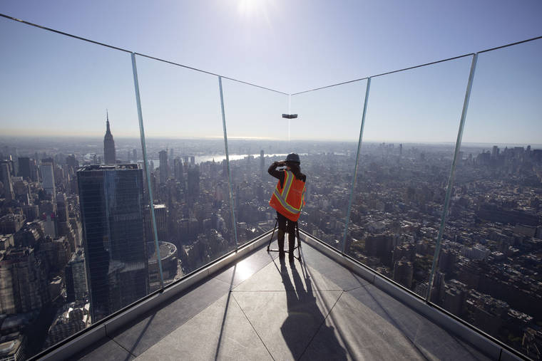 ASSOCIATED PRESS
                                A videographer works at “Edge,” an outdoor observation deck overlooking New York, during a media tour today. The deck at Hudson Yards opens to the public in March.