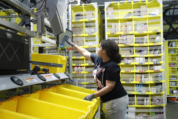 ASSOCIATED PRESS
                                A worker sorts through items and places orders at the Amazon Fulfillment Center in Staten Island in New York in June.