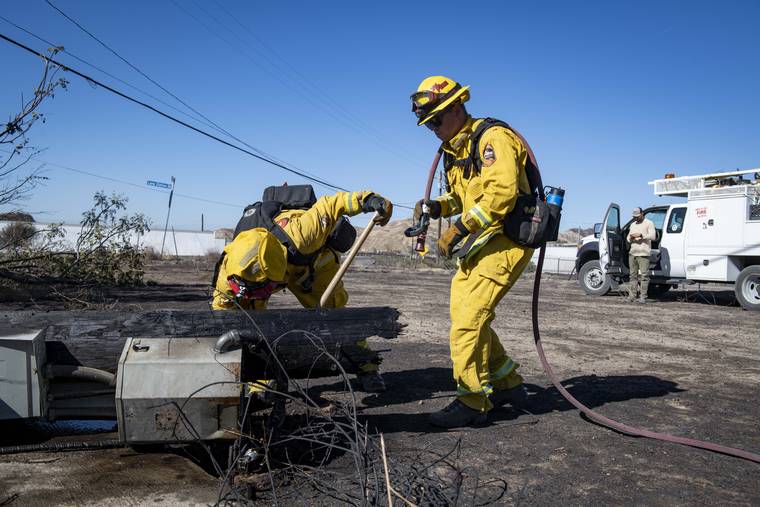 ASSOCIATED PRESS
                                Firefighters with Cal Fire examine a burned down low voltage power pole during the Tick Fire, Thursday in Santa Clarita, Calif. An estimated 50,000 people were under evacuation orders in the Santa Clarita area north of Los Angeles as hot, dry Santa Ana winds howling at up to 50 mph drove the flames into neighborhoods.