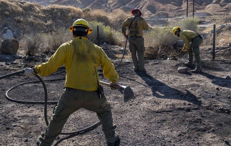 ASSOCIATED PRESS
                                An engine crew looks for any remaining hot spots from the Tick Fire in Santa Clarita, Calif. An estimated 50,000 people were under evacuation orders in the Santa Clarita area north of Los Angeles as hot, dry Santa Ana winds howling at up to 50 mph (80 kph) drove the flames into neighborhoods.