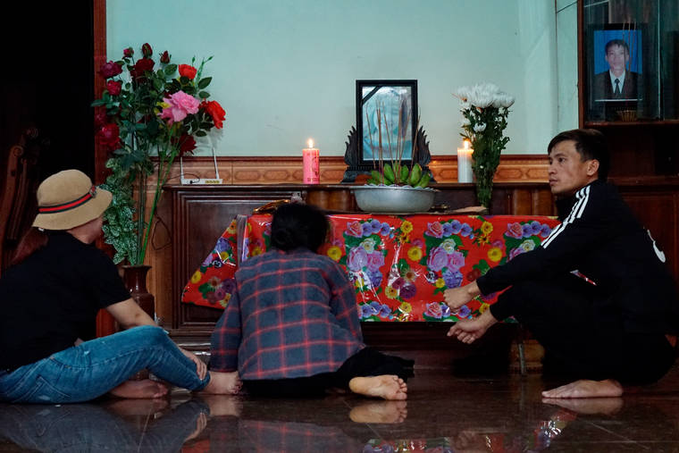 ASSOCIATED PRESS
                                The mother, center, and other relatives of Bui Thi Nhung sit in front of an altar with Nhung’s portrait inside her home today in Do Thanh village, Vietnam.