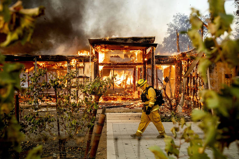 ASSOCIATED PRESS
                                Woodbridge firefighter Joe Zurilgen passes a burning home as the Kincade Fire rages in Healdsburg, Calif.