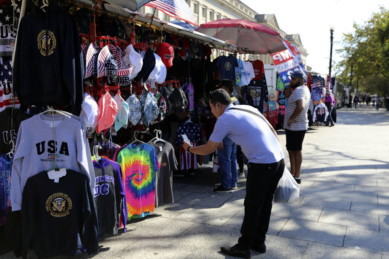 ASSOCIATED PRESS
                                A Chinese tourist takes pictures of Washington D.C. t-shirts at a tourism kiosk in Washington on Oct. 15. Across the country, the U.S. tourism industry is trying to counter one of the casualties of the trade war with China that is still raging despite this month’s temporary truce: A drop in the flow of affluent Chinese visitors to the United States.