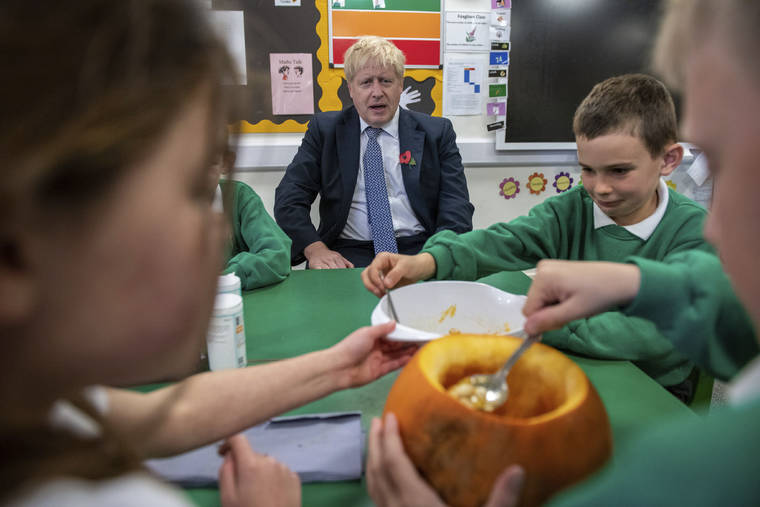 ASSOCIATED PRESS
                                Britain’s Prime Minister Boris Johnson sits with students as they carve pumpkins at Abbots Green Primary Academy in Bury St Edmunds, England today. The opposition Labour Party kicked off its campaign for Britain’s December general election with one overriding message Thursday: It’s not just about Brexit.