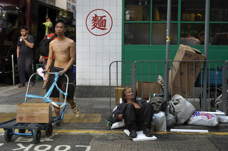 ASSOCIATED PRESS
                                A homeless man sleeps at street in Hong Kong. Business has plunged in Hong Kong’s shopping districts after more than four months of protests. The government announced today that the city is in a technical recession after it contracted for a second straight quarter.