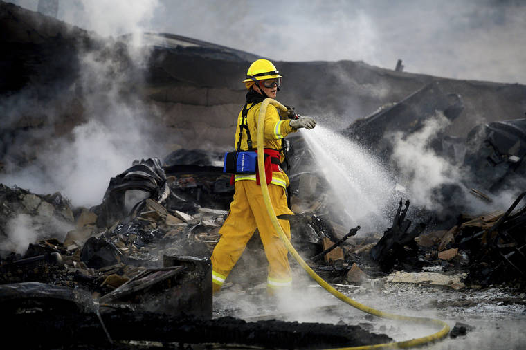 ASSOCIATED PRESS
                                A firefighter sprays water on a leveled home as the Hillside Fire burns in San Bernardino, Calif., today. Whipped by strong wind, the blaze destroyed multiple residences.