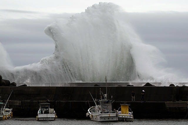 ASSOCIATED PRESS
                                Men look at fishing boats as surging waves hit against the breakwater while Typhoon Hagibis approaches at a port in town of Kiho, Mie Prefecture, Japan Friday, Oct. 11, 2019. A powerful typhoon is advancing toward the Tokyo area, where torrential rains are expected this weekend.