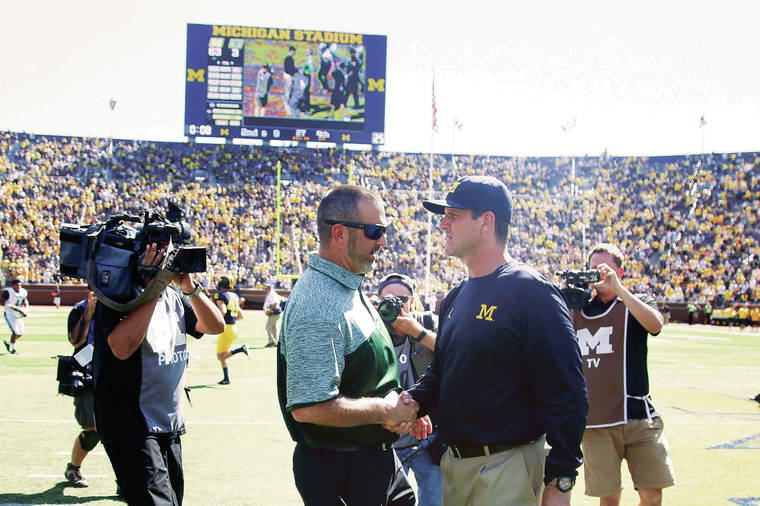 DAVID G. MCINTYRE / SPECIAL TO THE Star-Advertiser/ 2016
                                Hawaii head coach Nick Rolovich, left, and Michigan head coach Jim Harbaugh shook hands after the Wolverines’ 63-3 win over the Rainbow Warriors in Ann Arbor, Mich., in 2016.