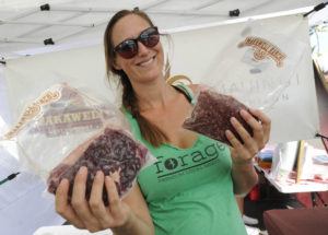BRUCE ASATO / MARCH 20, 2019
                                Jessica Rohr of Forage, shows off frozen packs of local grass fed beef Ribeye Steak, left, and Ground Beef at the Forage food booth at the FarmLovers Farmers Market at Kakaako.