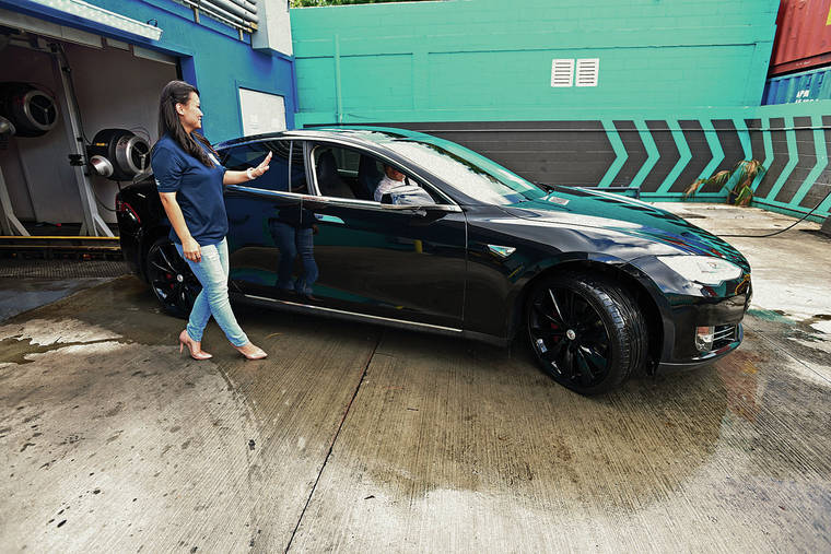 BRUCE ASATO/ BASATO@STARADVERTISER.COM
                                The state registered its 10,000th electric vehicle, or EV, in September. Judy Kim-Sugita, owner of The Car Parlor, thanked the driver of a Tesla Model S as it emerged from the Car Parlor car wash Wednesday.